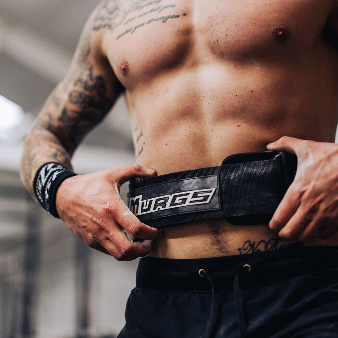 Male crossfit athlete securing Murgs 4 inch lifting belt