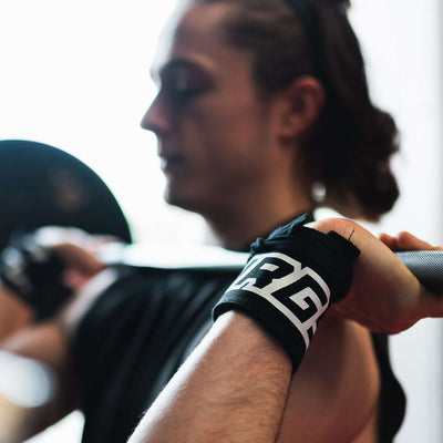 male athlete barbell pressing with Murgs cotton wrist wraps in black